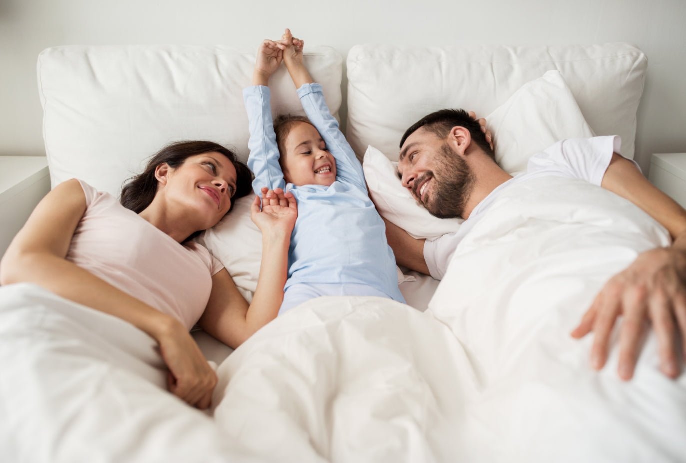 Family laying on bed